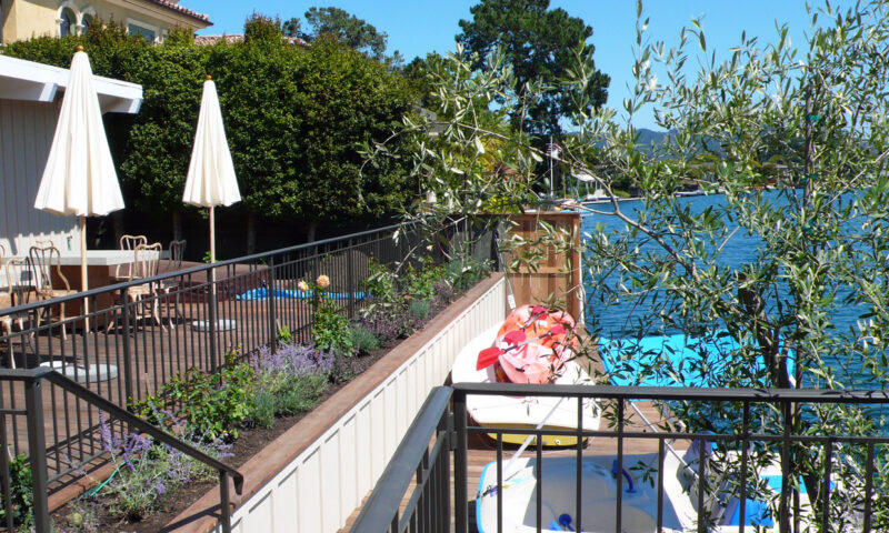 Patio overlooking lake with a boats and umbrellas.