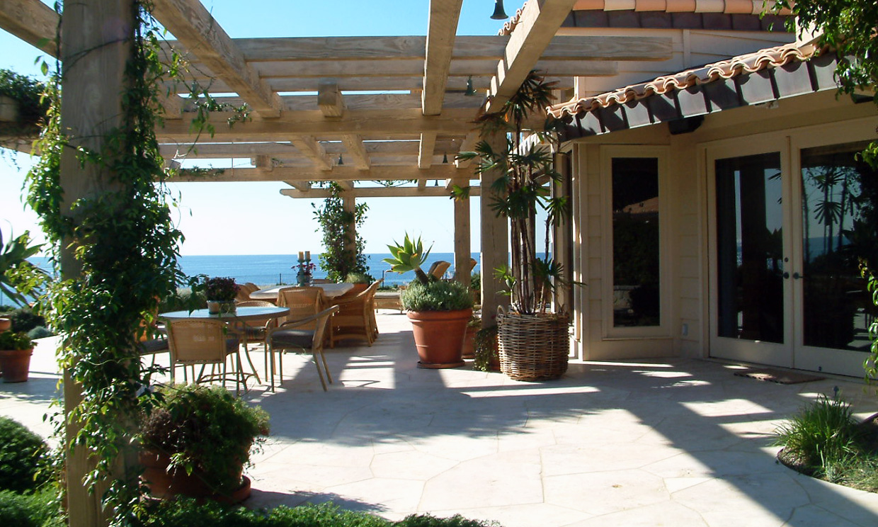 Outdoor patio with ocean view and pergola.