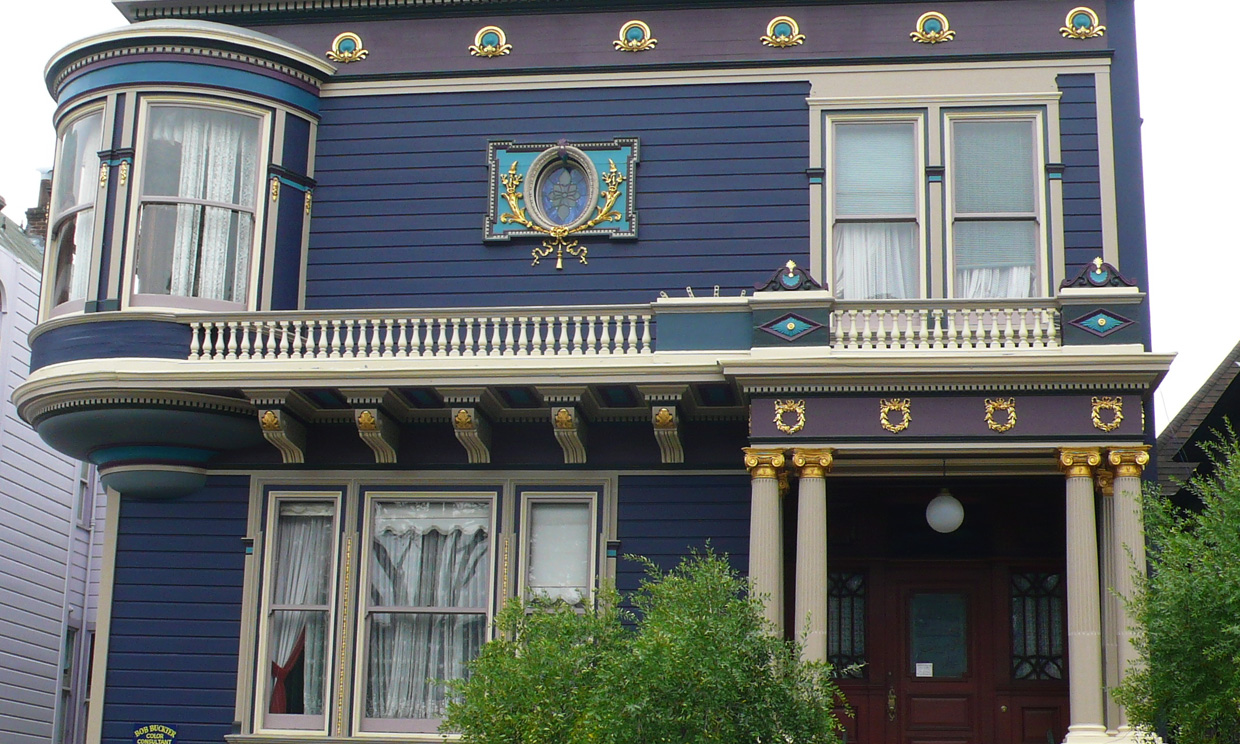 Victorian house with ornate details and a balcony.